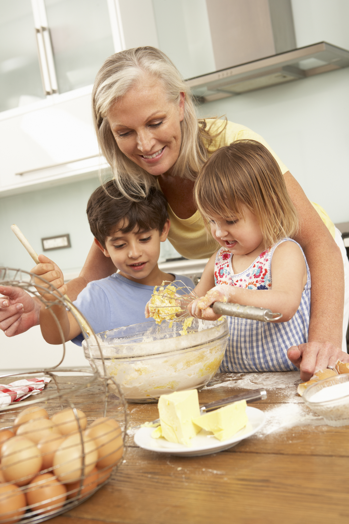 Grandchildren helping grandmother bake 
